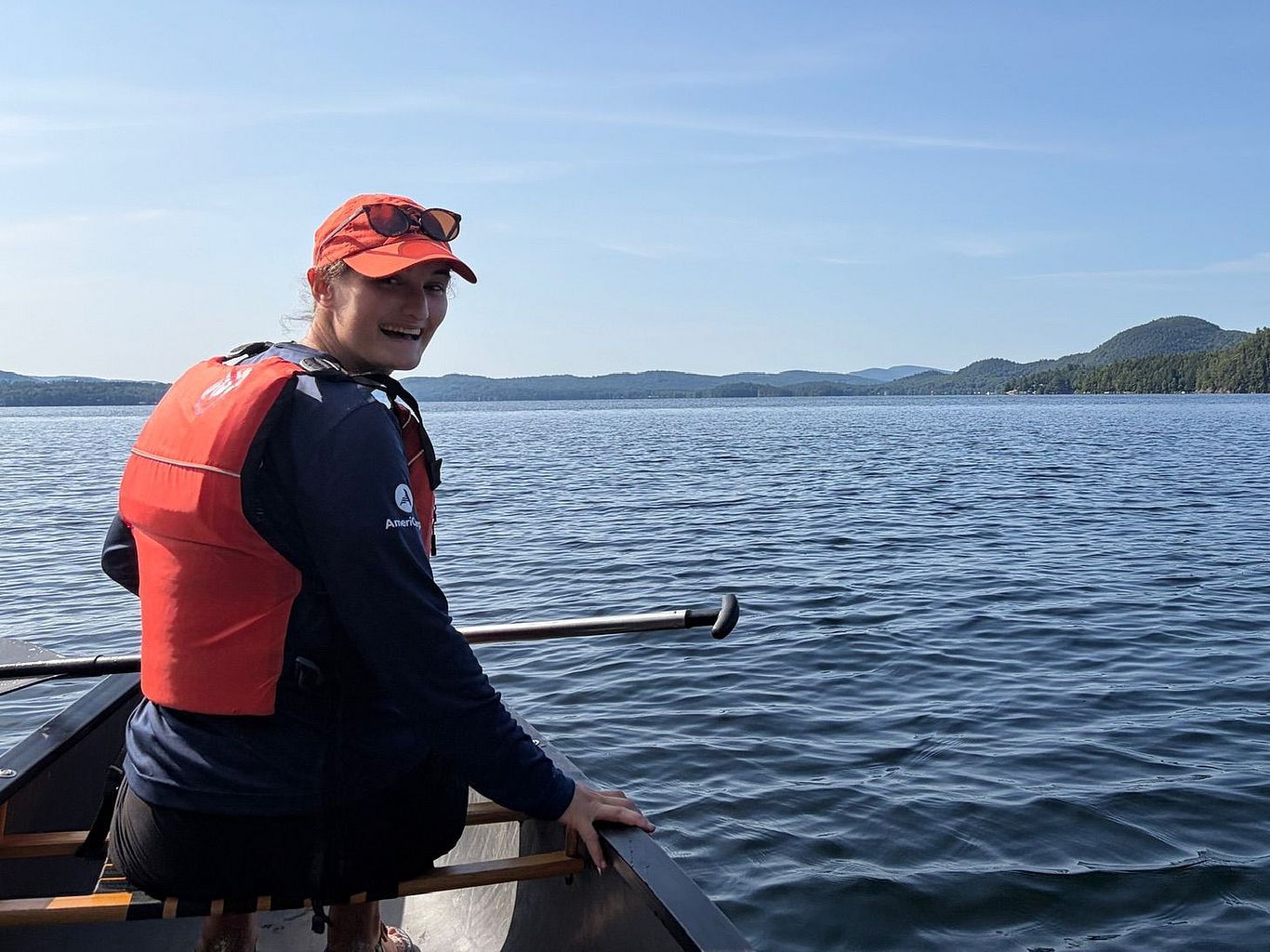 A Weed Watcher in a canoe look over their shoulder at the camera.