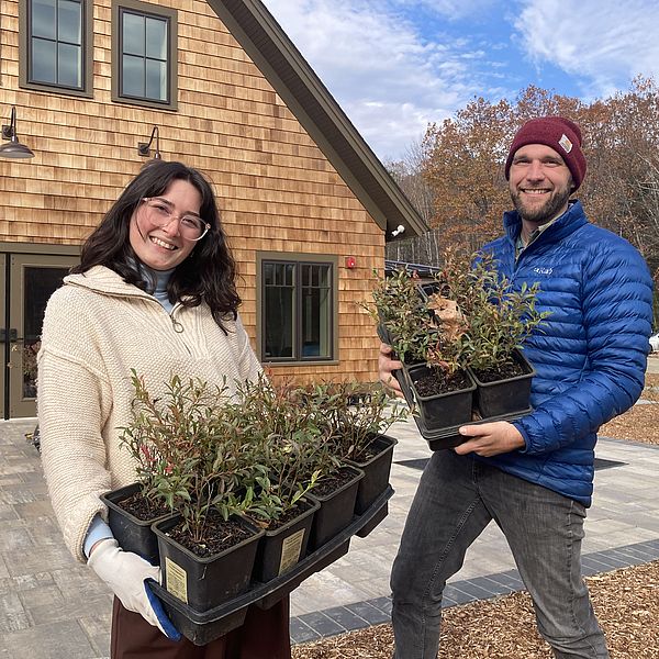 NLRA staff holding trays of native plants.