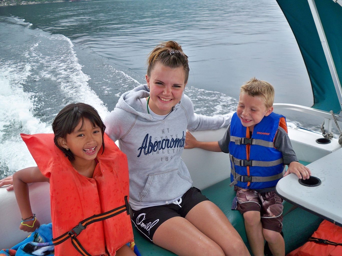 children on a boat enjoying the lake